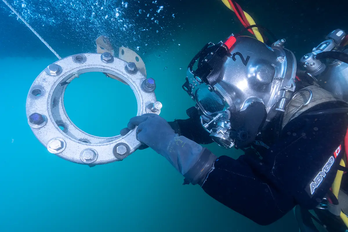 High-visibility underwater footage of diver handling flange component, captured with Digital Diver Camera System